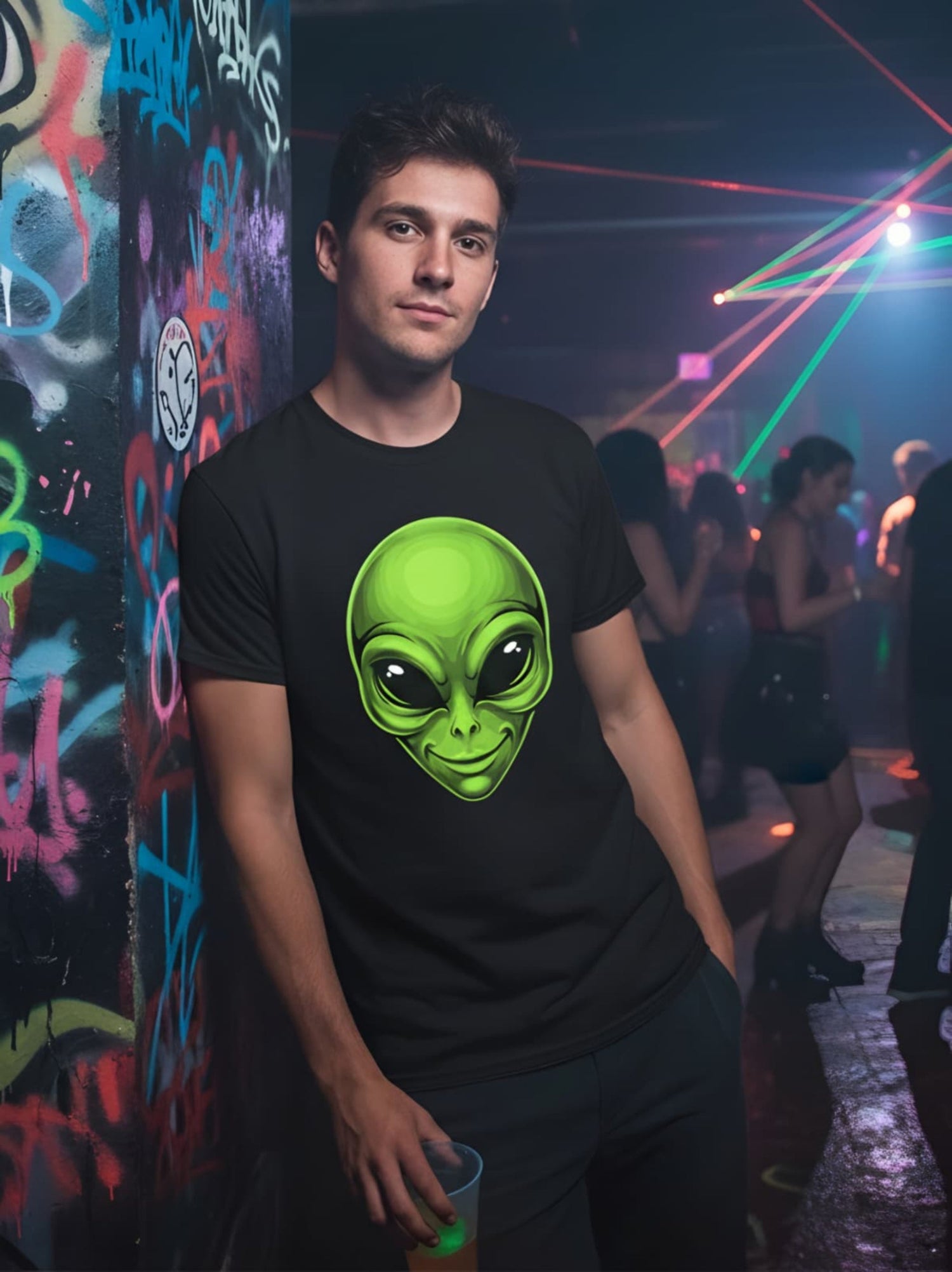 Person wearing a black t-shirt with a green alien graphic in a club setting