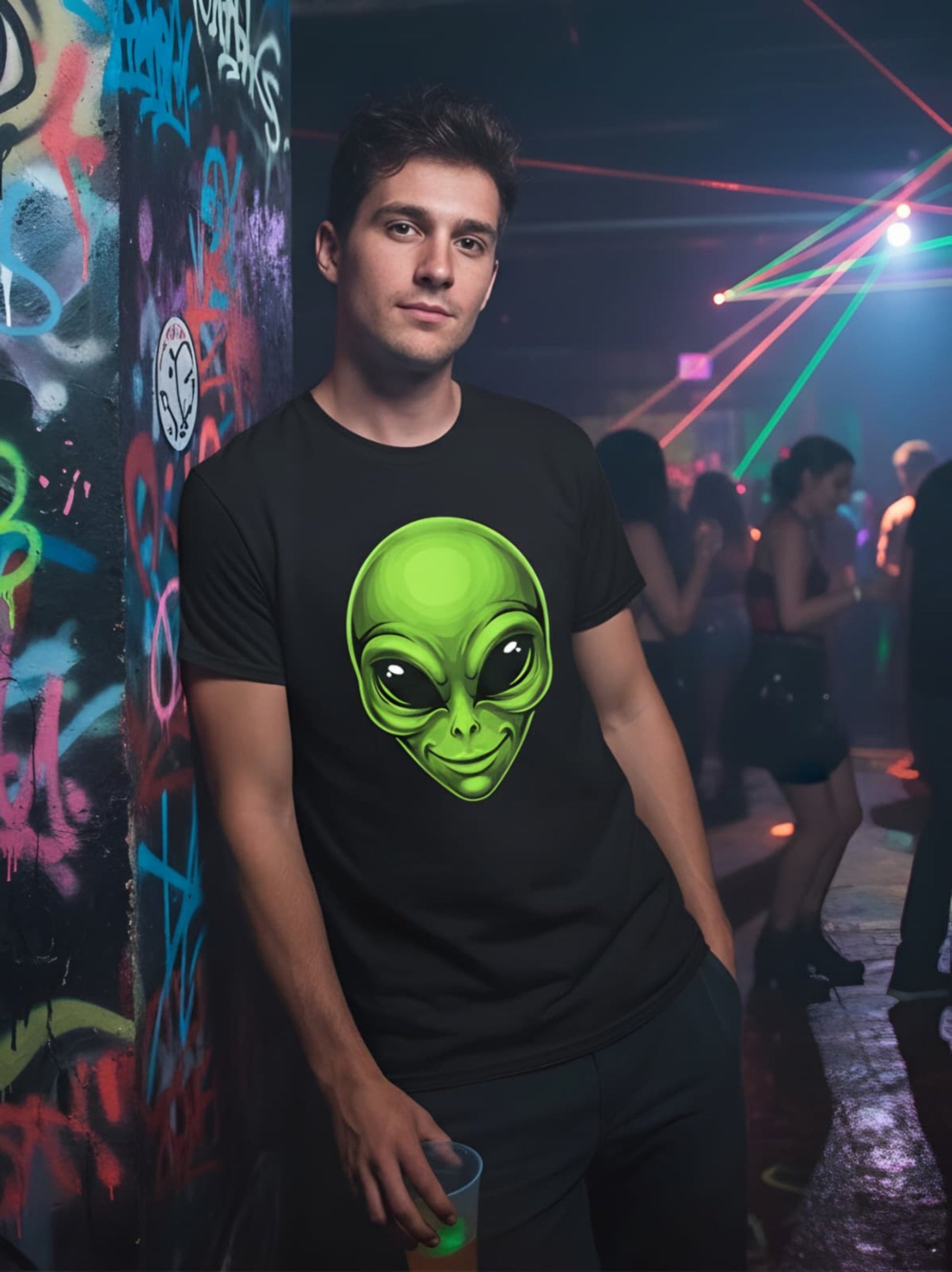 Person wearing a black t-shirt with a green alien graphic in a club setting